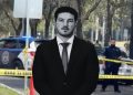 Man in a Black Suit and Tie Stands in Front of a Crime Scene with Yellow Police Tape and Police Cars in the Background. | Nl Urbano